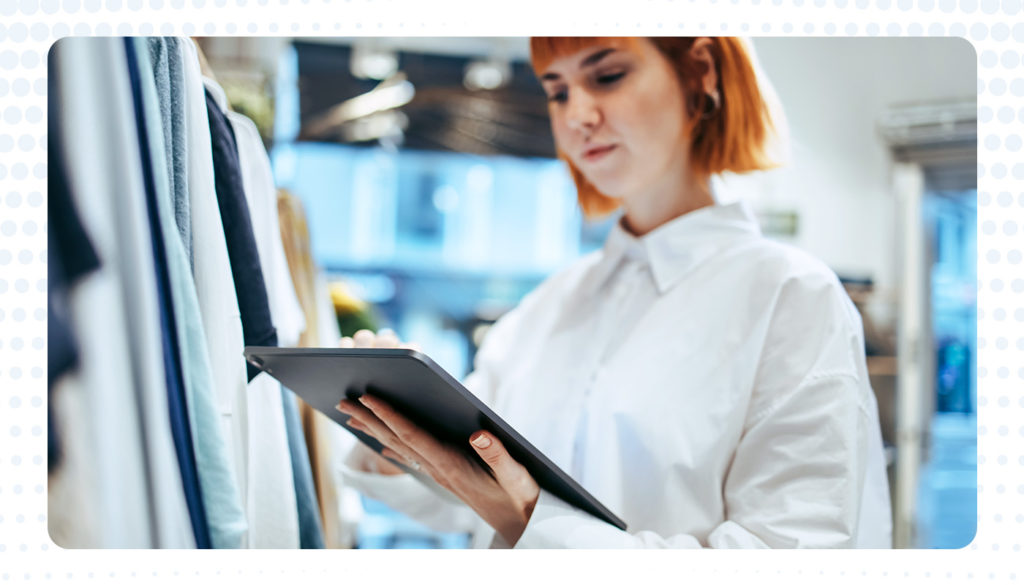 woman using an iPad to view people counting data inside a clothing retail store