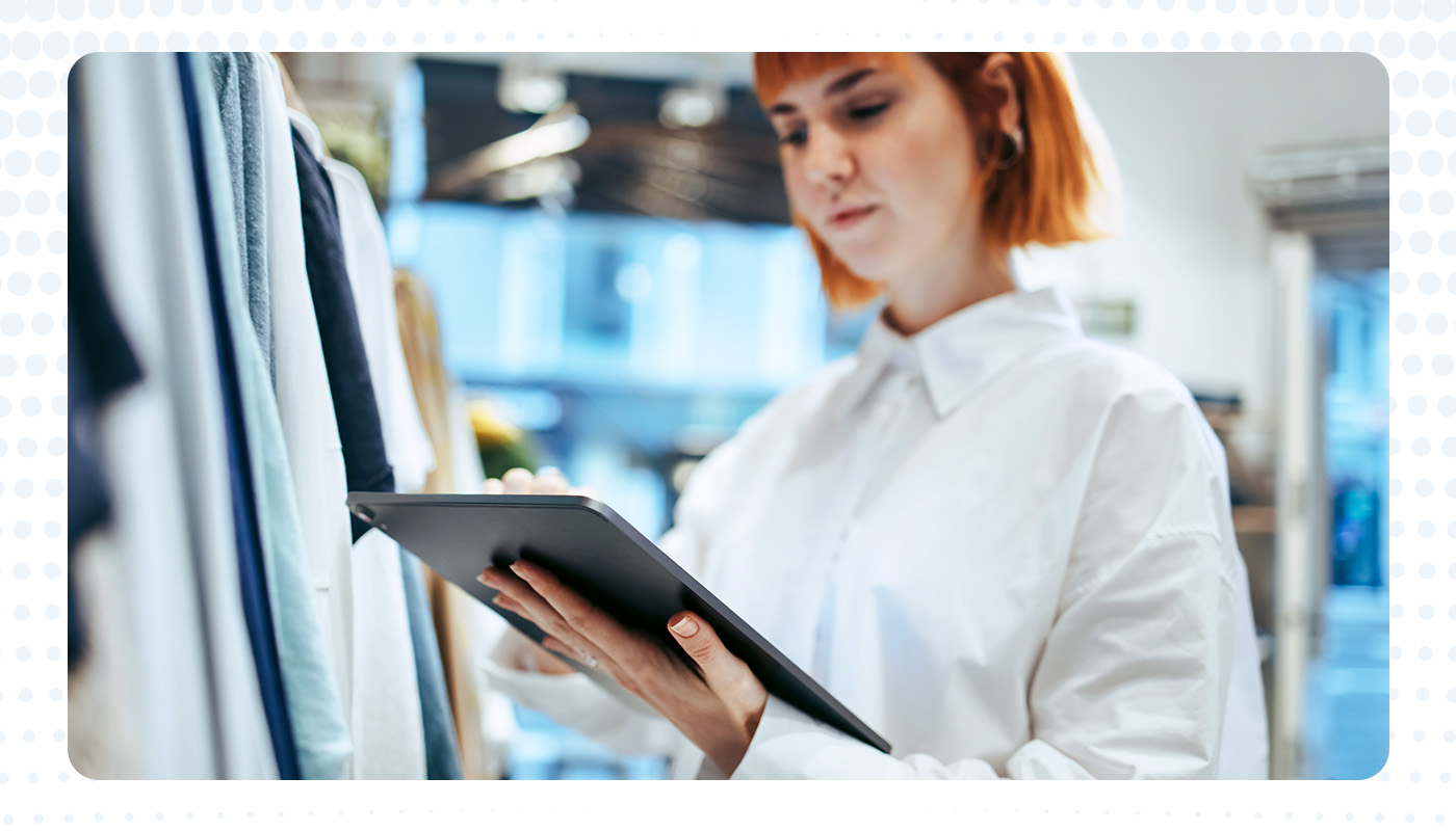 woman using an iPad to view people counting data inside a clothing retail store