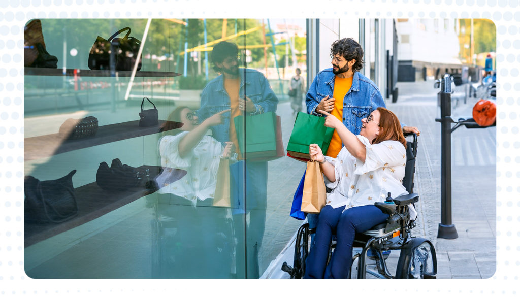 woman in wheelchair shopping for a purse behind glass window